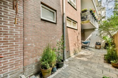 Tuğladan duvarlarla çevrili huzurlu bir yol, yemyeşil ve rahat bir oturma alanı ile süslenmiş, sükuneti ve rahatlığı davet eden..