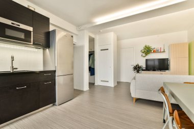 Modern aletler, temiz hatlar ve rahat bir atmosfer içeren gösterişli ve çağdaş bir mutfak ve oturma odası. Minimalist bir yaşam tarzı için ideal..