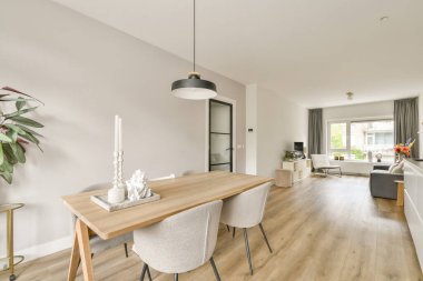 Zarif bir yemek alanı, minimalist bir masa, zarif sandalyeler ve ambiyansı arttıran parlak bir pencere manzarası olan modern iç mekan..