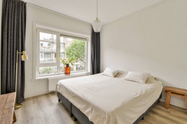 Huzurlu, modern bir yatak odası. Yatak odası, pencereden yansıyan doğal bir ışık ve minimalist bir dekor. Rahatlık ve sadeliğin mükemmel bir karışımı..
