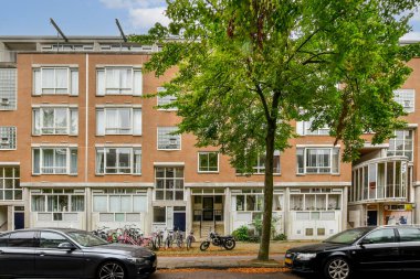 Geniş pencereleri ve yeşillikleri olan çağdaş bir kentsel yapı. Bisikletler cadde boyunca park halinde, toplum atmosferini ve sürdürülebilirliğini arttırıyorlar..