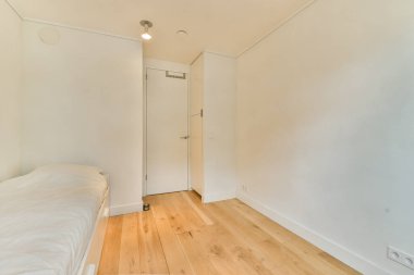 Minimalist bir iç mekan, ahşap döşemeli, ince ışıklandırmalı, sadeliği ve zarafeti vurgulayan temiz bir tasarım sergiliyor..