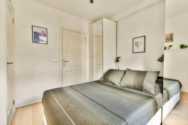 Doğal ışık ve temiz çizgilerle tamamlanmış rahat bir yatak odası ve minimalist dekoru olan parlak ve şık bir modern yatak odası..