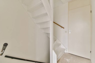 Üst kata çıkan parlak modern bir merdiven, minimalist tasarım ve çağdaş mekanlar için temiz bir estetik tasarım içeriyor..