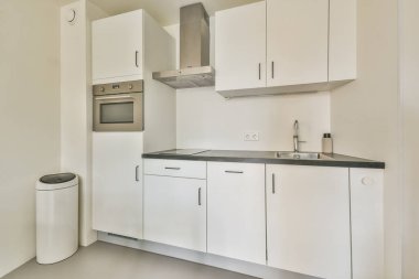 Gösterişli ve modern bir mutfak, minimalist dolap, düzenli bir düzen ve işlevselliği ve tarzı geliştiren modern aletler..