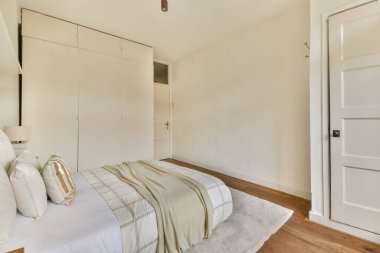 Yumuşak nötr tonları, basit mobilyaları ve rahatlığı arttıran rahat bir atmosferi olan sakin, modern bir yatak odası..