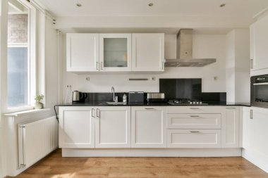 Modern aletlerle donatılmış şık ve çağdaş bir mutfak ve işlevsellik ve stile odaklı minimalist bir estetik..