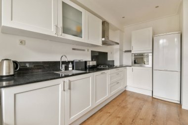 Zarif dolap şiirleri, paslanmaz çelik aletler ve estetiği pratiklikle birleştiren işlevsel bir düzen içeren modern mutfak..