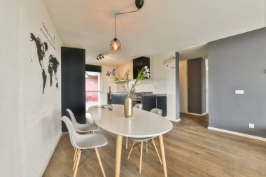 Zarif bir masa, zarif sandalyeler ve dünya haritası duvar resminin yer aldığı şık bir yemek odası çağdaş bir atmosfer yaratıyor..