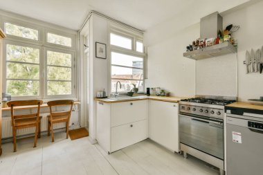 Modern aletleri olan parlak ve havadar bir mutfak, minimalist dekor ve yemek pişirmek için ideal temiz ve işlevsel bir düzenle geniş doğal ışık..