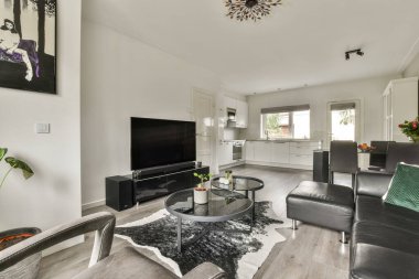 Zarif bir tasarımı olan modern bir oturma odası rahat koltuklar, çağdaş bir TV ünitesi ve zarif dekoratif unsurlar..