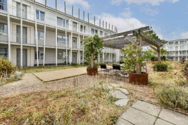 Yeşil peyzaj, açık hava oturma alanları ve dinlenme ve boş zaman aktiviteleri için sakin bir yol içeren modern bir konut binası..