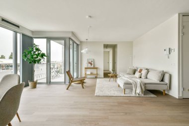 Minimalist dekorun, geniş pencerelerin ve rahat bir oturma düzeninin olduğu parlak ve havadar bir oturma odası. Rahatlama ve sosyal toplantılar için mükemmel..