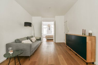 Doğal ahşap döşeme ve minimalist dekorun yer aldığı geniş, modern bir iç mekan. Zarif bir yaşam alanında sakin bir atmosfer oluşturuyor..