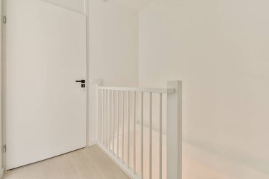 Beyaz duvarlar ve parmaklıklardan oluşan parlak ve minimalist bir merdiven, açık ve havadar bir atmosfer yaratıyor. Çağdaş iç tasarım ilhamları için ideal..