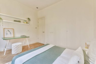 Minimalist bir tasarımı, yumuşak renk paletleri ve sakin bir atmosfer yaratan şık dekorları olan geniş ve iyi ışıklandırılmış bir yatak odası..