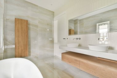 Bu çağdaş banyo zarif tasarımlar, zarif aksesuarlar ve sakinleştirici bir renk paleti içeriyor, sakin ve davetkar bir atmosfer yaratıyor..