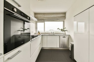 Entegre cihazları ve parlak bir atmosferi olan minimalist bir estetiğe sahip gösterişli ve çağdaş bir mutfak. Modern yaşam için ideal..