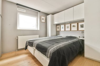 Zarif ve şık bir yatak odası, rahat bir yatak odası, minimalist bir dekor, ve geniş bir pencereden bol miktarda doğal ışık..