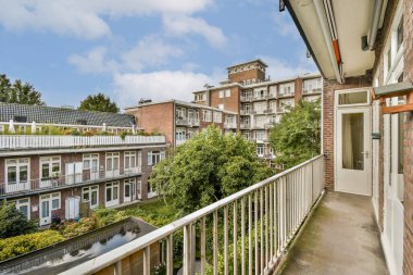 Balkondan sakin bir manzara yemyeşil ve şehir binalarını gözler önüne seriyor, doğayı canlı bir atmosferde çağdaş mimariyle harmanlıyor..