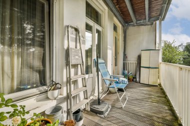 İçinde rahat bir sandalye, saksı bitkileri ve manzarası olan iyi döşenmiş bir balkon. Rahatlamak ve dışarıda eğlenmek için mükemmel..