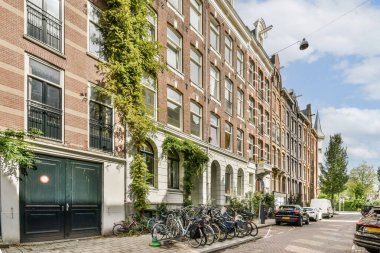 Amsterdam 'da yemyeşil bir cadde, geleneksel mimari ve park edilmiş bisikletler, eşsiz kültür ve yaşam tarzını somutlaştırıyor..