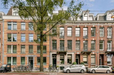 Parlak renkli geleneksel binalar, Amsterdam 'ın eşsiz mimari tarzını gözler önüne seren sakin bir cadde. Bisikletler ve park halindeki arabalarla tamamlanmış..
