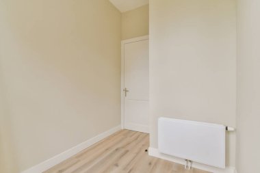 Temiz, boş bir oda. Minimalist iç tasarımı sergiliyor. Yumuşak renkler ve doğal ışık, sakin bir atmosfer yaratıyor..