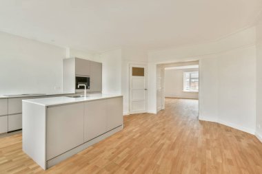 Geniş, modern bir mutfak, gösterişli bir dolap, açık bir düzen, ve sıcak ahşap döşeme, çağdaş yaşam alanları için ideal..