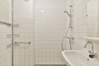 Gösterişli ve minimalist banyo tasarımı. Beyaz fayanslı duvarlar, zarif eşyalar ve temiz bir estetik. Çağdaş yaşam alanları için mükemmel.