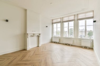 Geniş ve iyi ışıklandırılmış geniş pencereleri ve zarif döşemeleri olan modern oda. Minimalist tasarım çeşitli kullanımlar için yeni bir ortam sunar..