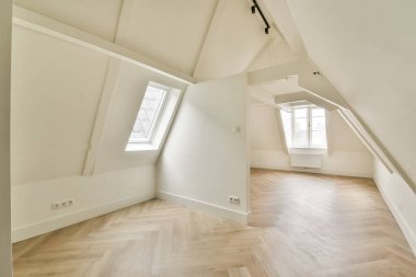 Açılı tavanlar, geniş pencereler ve sıcak ve davetkar bir atmosfer yaratan ahşap döşeme modern bir iç mekan. Çağdaş yaşam alanları için ideal.