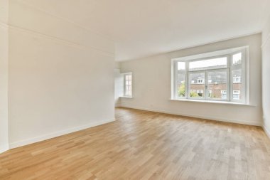 Temiz duvarları ve ahşap döşemeleri olan havadar ve iyi aydınlatılmış boş bir oda. Geniş pencere doğal ışık getiriyor, çeşitli iç tasarım olanakları için mükemmel..