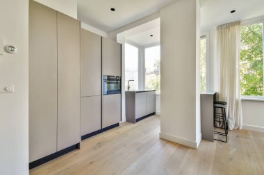 Gösterişli dolaplar, büyük pencereler ve doğal ışık barındıran çağdaş bir mutfak. Minimalist tarzda işlevsellik ve estetik için tasarlanmış..