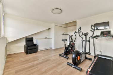 Egzersiz ekipmanları ve minimalist tasarımı olan, spor meraklıları için mükemmel bir modern spor salonu. Düzenleme fitness için işlevsel bir alan oluşturur.