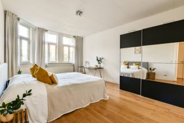 Zarif bir yatak odası, minimalist bir estetik, rahat bir yatak odası, zarif bir dekor ve büyük pencerelerden yayılan doğal bir ışık..