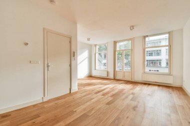 Sıcak ahşap döşeme ve minimalist tasarım ile tamamlanmış, doğal ışık getiren geniş pencereli geniş, aydınlık bir oda. Çeşitli kullanımlar için ideal.