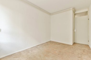 Boş bir oda, minimalist tasarım, çıplak duvarlar ve süslenmemiş bir zemin, açıklık ve basitlik hissi yaratıyor..
