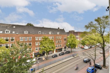 Şehir manzaralı şehir manzaralı ağaçlar şehir caddesinde çeşitli binalar ve park edilmiş arabalarla canlı atmosferi yükseltiyor..