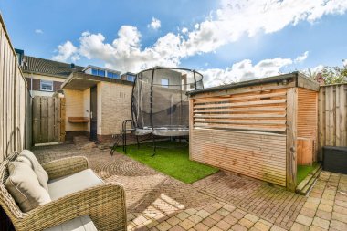 Trambolini, ahşap çitleri ve rahat koltukları olan güzel manzaralı bir bahçe. Açık hava rahatlığı ve eğlenceli aktiviteler için mükemmel..