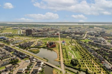 Görüntü, doğa ve modern altyapının bir karışımını vurgulayan parklar, yollar ve nehirlerin yer aldığı genişleyen bir kentsel alanı gösteriyor..