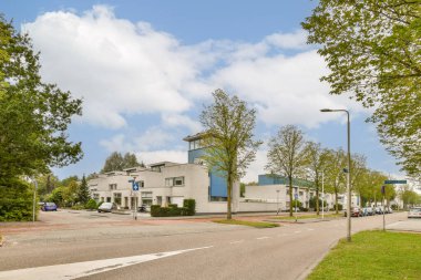 Çağdaş mimari, berrak gökyüzü ve caddelerde yemyeşil verimli bir manzaraya sahip canlı bir şehir manzarası, doğa ve kentsel yaşamın uyumlu bir karışımını sergiliyor..