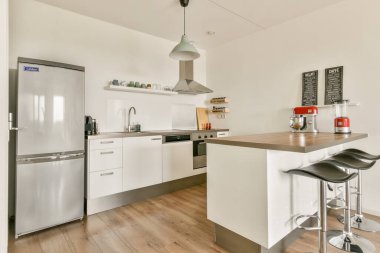 Çağdaş aletlerin yer aldığı şık ve şık bir modern mutfak, minimalist bir tasarım, ve zarif ahşap döşeme, yemek ve eğlence için mükemmel..