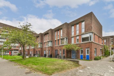 Çağdaş tasarım elementlerinin bir karışımı gösteriliyor, bu şehir konutu eşsiz geometrik şekiller ve yeşil çevreli şık bir cephe içeriyor..