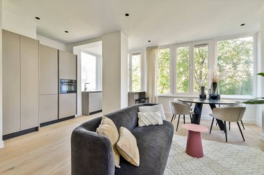 Parlak ve havadar, geniş pencereli, parlak mobilyalı ve doğal elementlerle dolu rahat bir atmosferi olan modern oturma odası. Konfor ve tarzın mükemmel bir karışımı..
