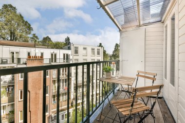 Konforlu bir apartman balkonundan sakin bir manzara binalar ve yeşillikler, modern mimari ve barışçıl bir atmosfer..