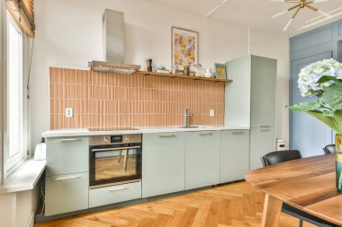 Bu modern mutfak şık bir kabin karışımı, sıcak bir renk paleti ve çağdaş aletler içeriyor, bir karşılama ve işlevsel alan yaratıyor..