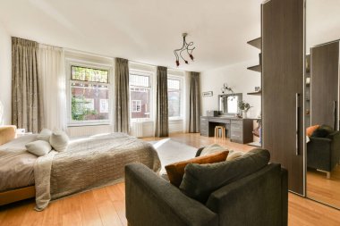 Rahat bir yatak odası, şık mobilyalar ve sıcak ve davetkar bir atmosfer yaratan bol miktarda doğal ışık..