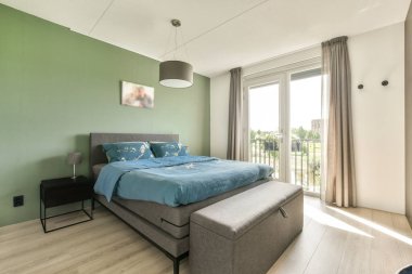 Rahat bir yatak odası, şık bir dekor ve bol doğal ışık içeren gösterişli ve davetkar bir yatak odası. Rahatlamak için sakin bir atmosfer yaratıyor..