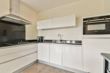 Minimalist dolap şiirleri, paslanmaz çelik aletler ve yer ve işlevselliği en üst düzeye çıkaran açık bir düzen içeren çağdaş bir mutfak. Modern yaşam için ideal..